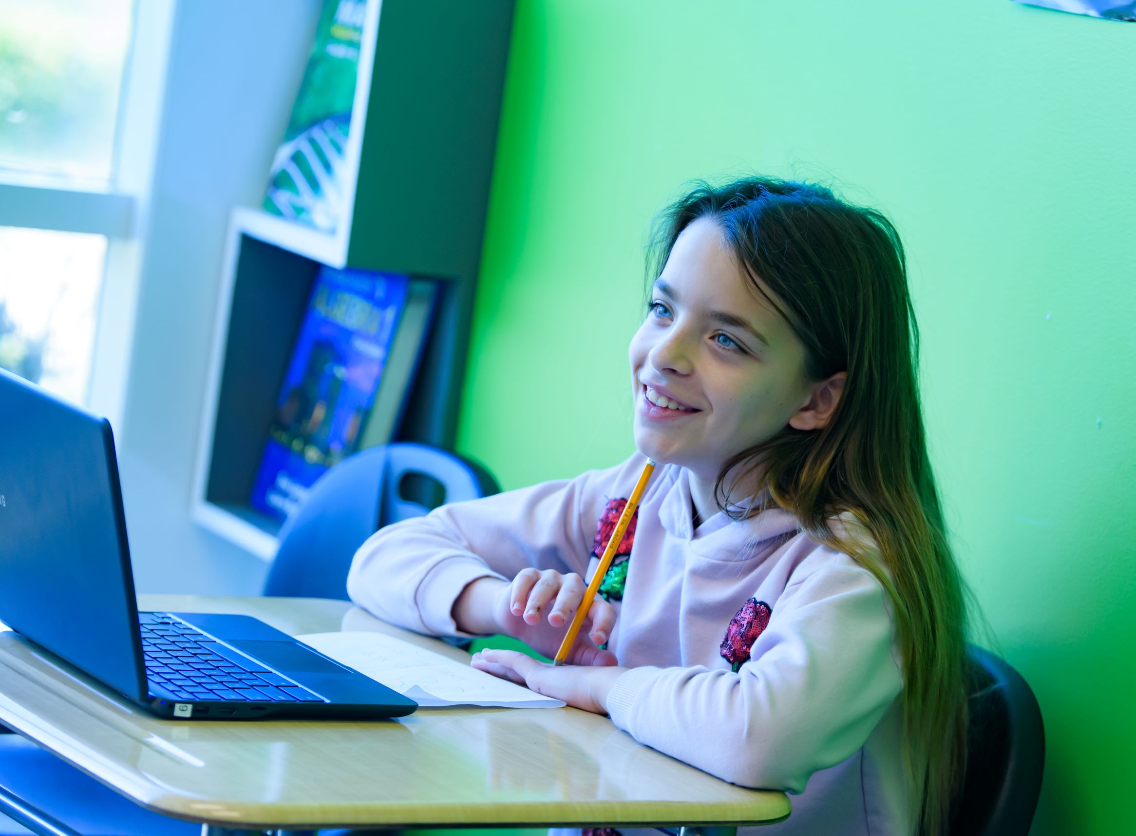 a young student at score academy learning on her laptop