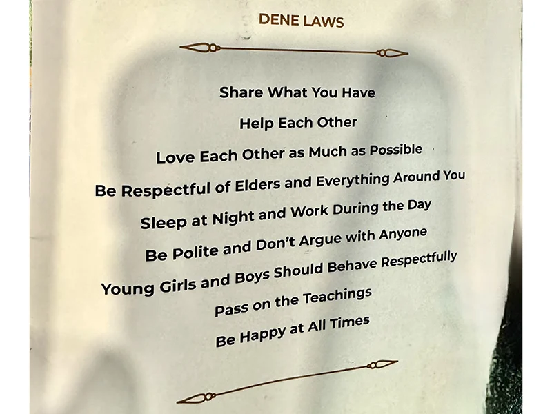 A paper sign that says "Dene laws" with the laws listed in bold text below